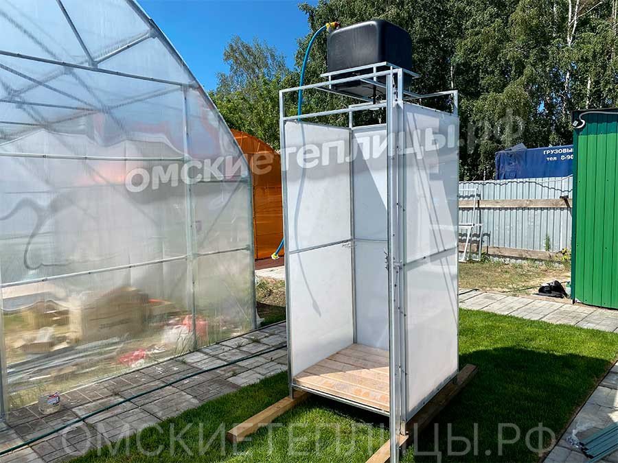 Летняя душевая кабина из поликарбоната с баком, установленная на участке в Омской области